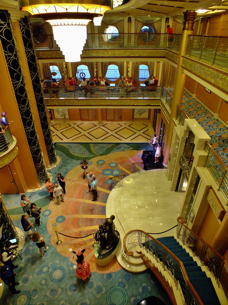 Disney Magic atrium with its sweeping staircase and bronze Helmsman Mickey statue