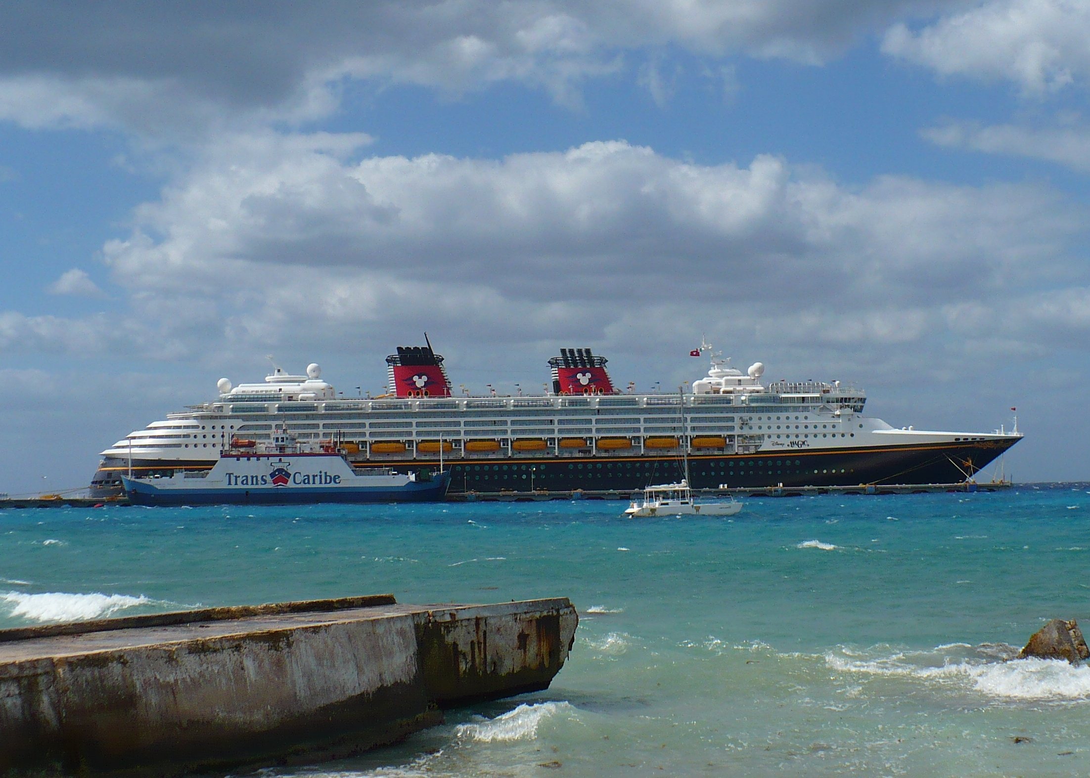 Disney Magic docked at Cozumel with its navy hull and two red funnels visible