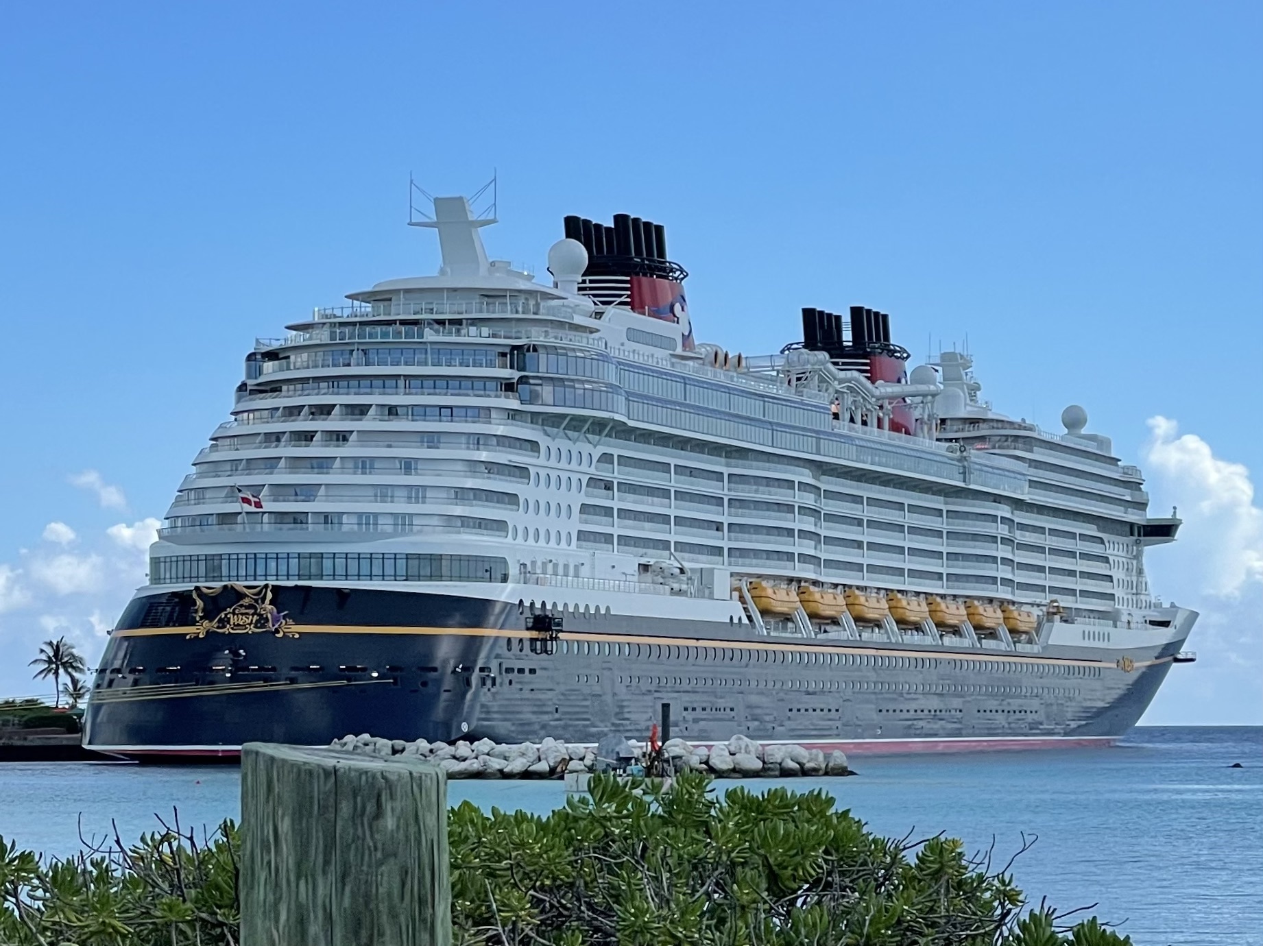Disney Wish docked at Disney Castaway Cay beneath a blue sky